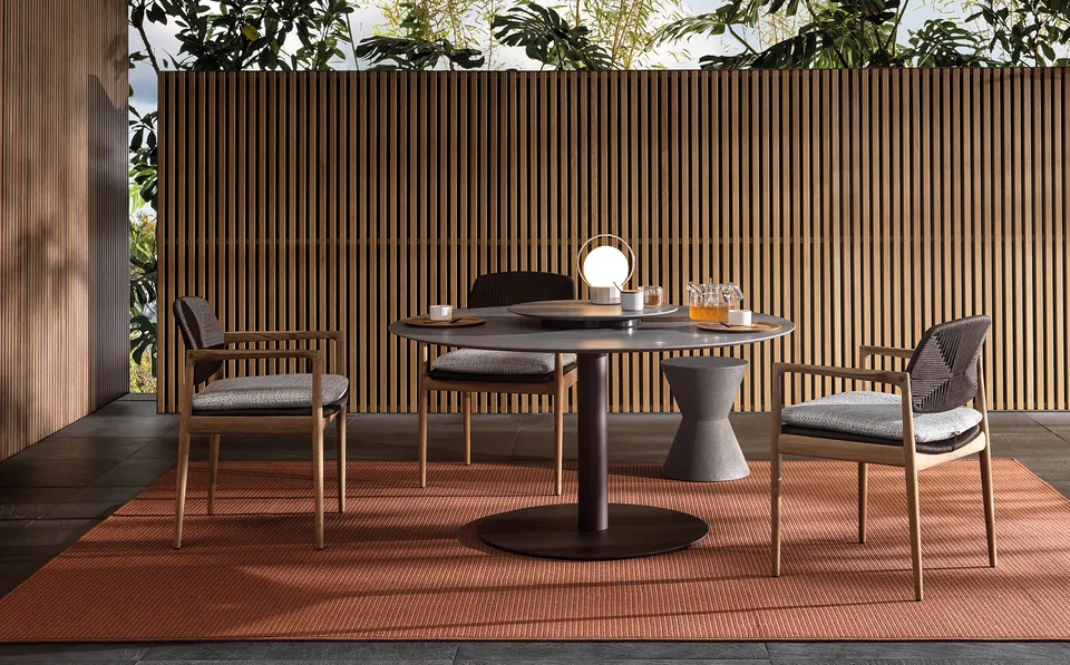 Minotti Bellagio round stone outdoor dining table on a terrace, Minotti outdoor furniture
