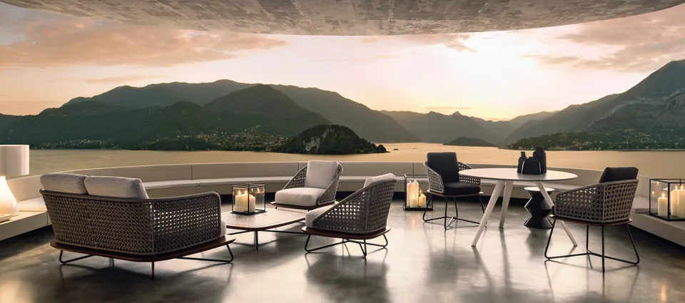 Minotti Rivera outdoor armchair with iroko base and woven back on a lakeside veranda, Minotti outdoor furniture