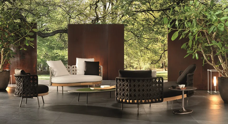 Minotti Torii Nest curved outdoor sofa with round woven cord back on a city terrace, Minotti outdoor furniture